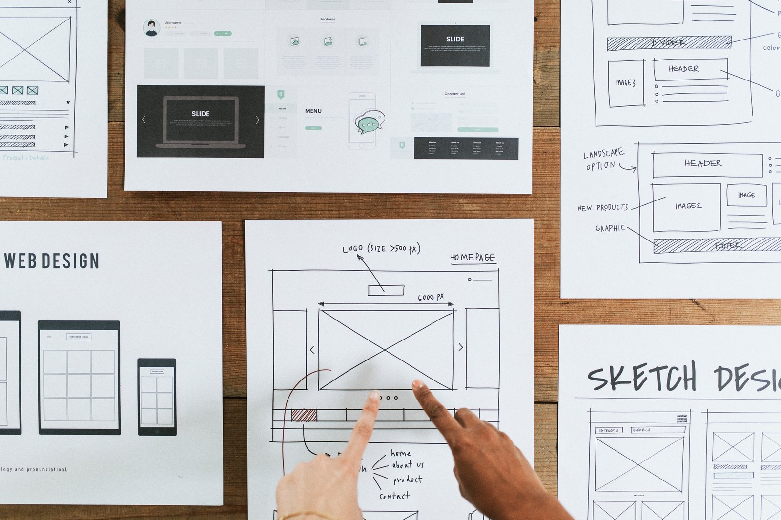 Hands point to web design document